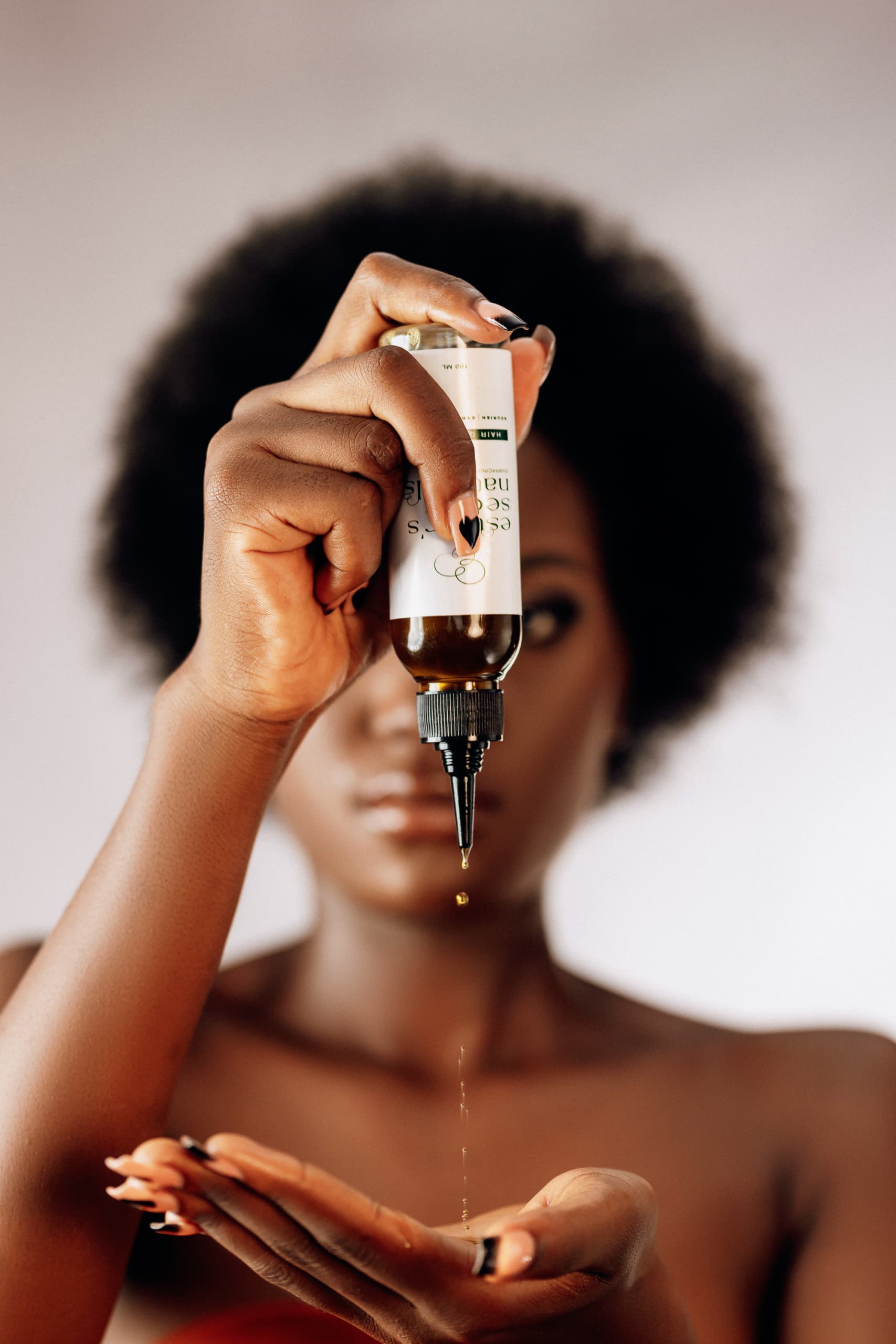 Model applying Esther's Secret Natural hair oil